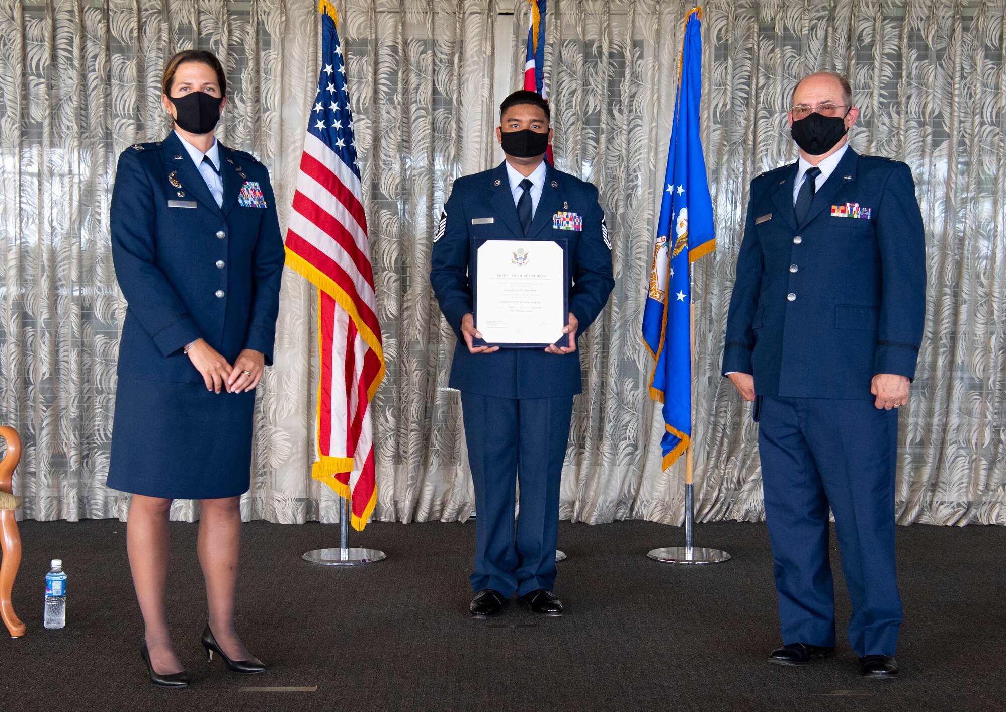 A photo of U.S. Air Force Col. Athanasia Shinas, 624th Regional Support commander, presenting Col. Lee Bradshaw, the former commander of the 624th Aeromedical Staging Squadron, with the certificate of retirement during his retirement ceremony at Joint Base Pearl Harbor-Hickam, Hawaii, Aug. 9,  2020.