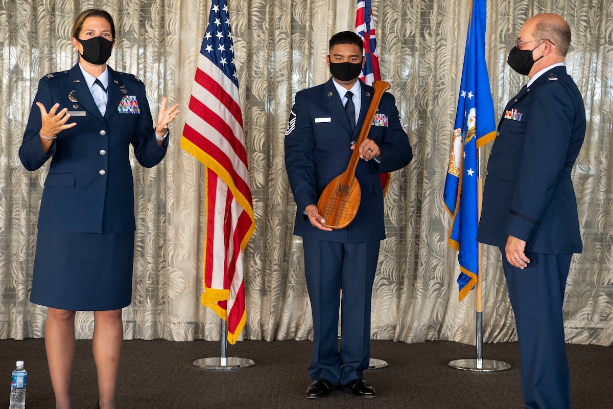 A photo of U.S. Air Force Col. Athanasia Shinas, 624th Regional Support commander, presenting Col. Lee Bradshaw, the former commander of the 624th Aeromedical Staging Squadron, with a Koa wood paddle during his retirement ceremony at Joint Base Pearl Harbor-Hickam, Hawaii, Aug. 9, 2020.