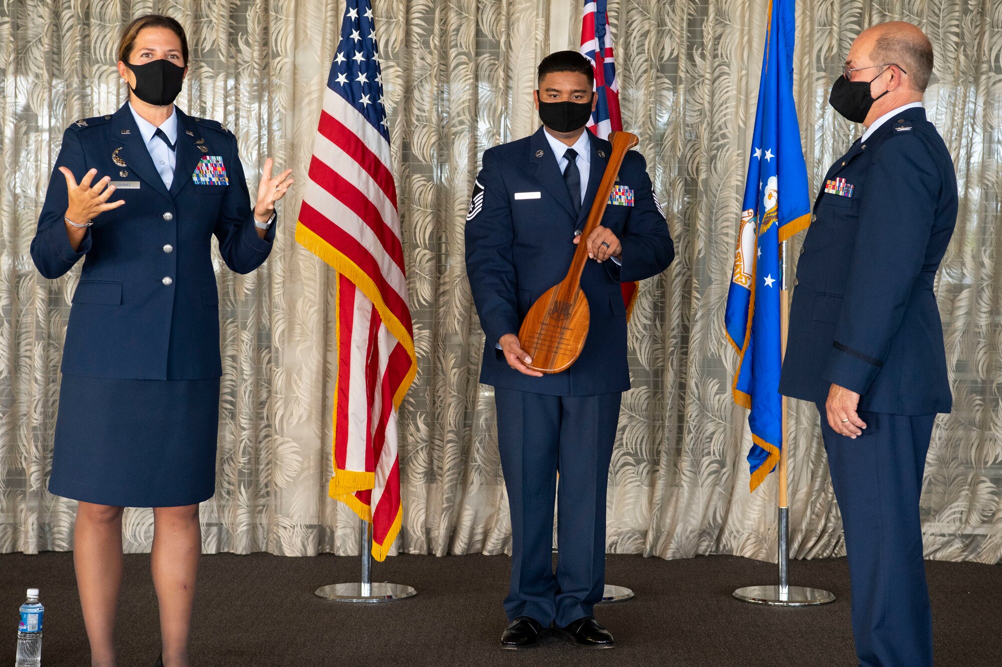 A photo of U.S. Air Force Col. Athanasia Shinas, 624th Regional Support commander, presenting Col. Lee Bradshaw, the former commander of the 624th Aeromedical Staging Squadron, with a Koa wood paddle during his retirement ceremony at Joint Base Pearl Harbor-Hickam, Hawaii, Aug. 9, 2020.