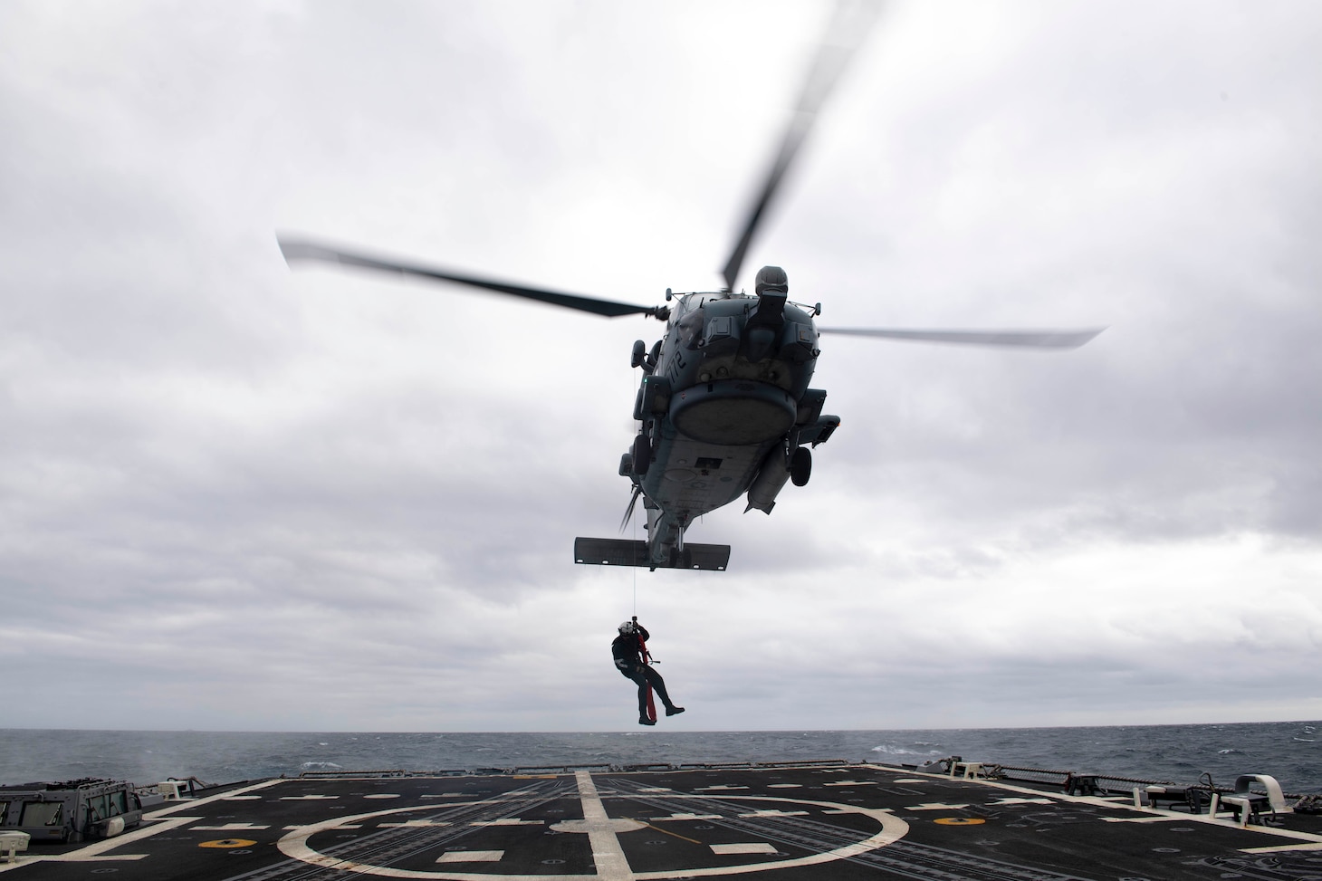 A Sailor performs a search-and-rescue live-hoist drill on the flight deck of USS Thomas Hudner (DDG 116).