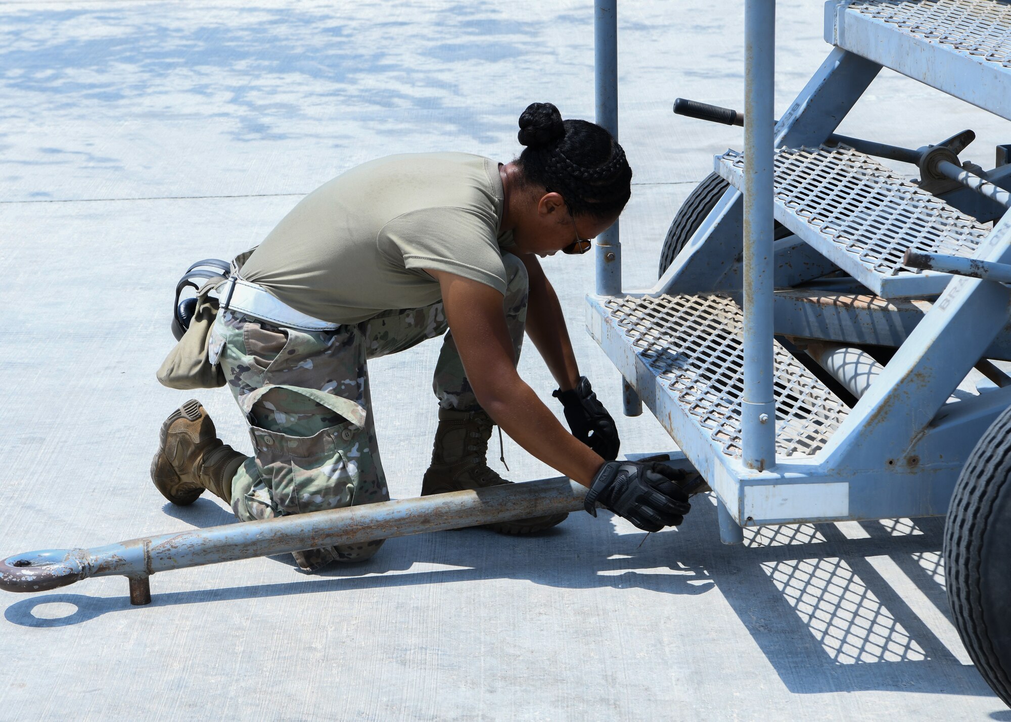 Senior Airman Brittany Cooke-McMath, a 380th Expeditionary Maintenance Squadron KC-10 Extender crew chief, prepares to move stairs before the aircraft takes off at Al Dhafra Air Base, United Arab Emirates, Aug. 18, 2020.