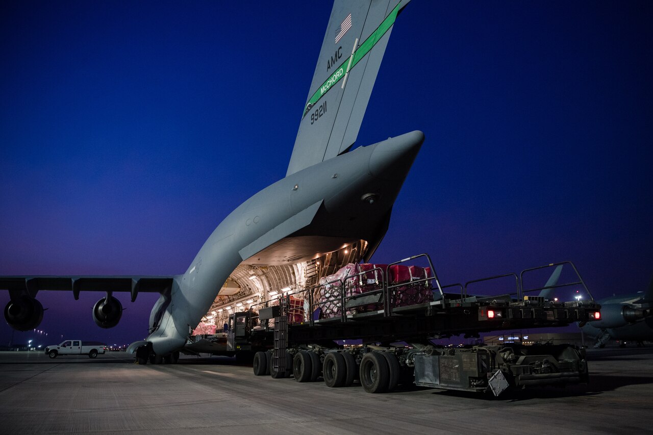 Supplies loading onto back of giant aircraft.