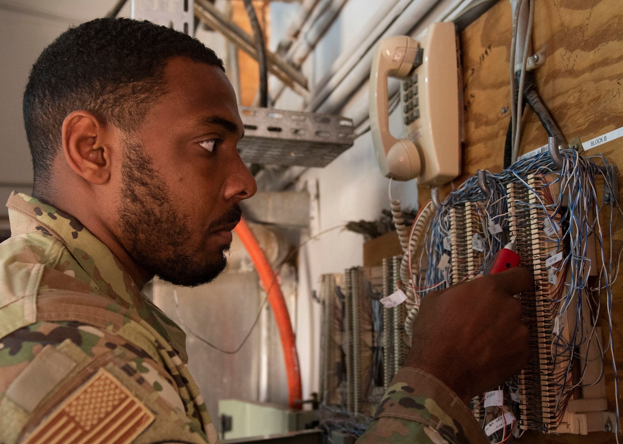 U.S. Senior Airman Muhammad Jackson test phone lines for bad connections.