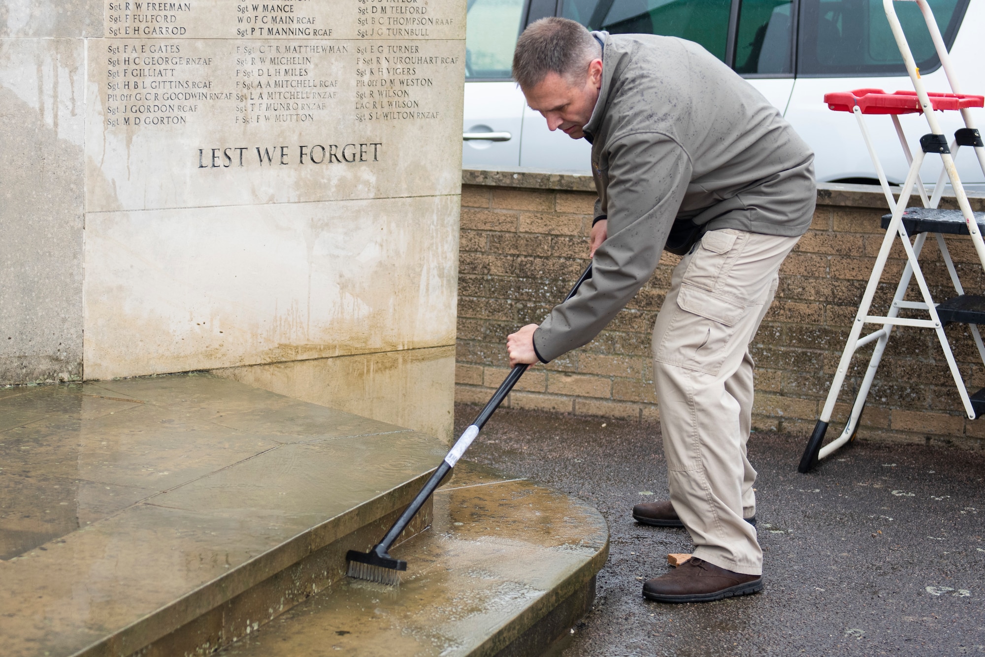 U.S. Army Col. Brian Dunmire, USAFRICOM J2-M director and multi-service commander, scrubs the 355th Fighter Group Steeple Morden Memorial in Steeple Morden, England, during Operation TORCH-2020 memorial cleanup August 15, 2020. U.S. Africa Command Directorate for Intelligence at RAF Molesworth partnered with the American Battle Monuments Commission to host Operation TORCH-2020, where over 50 military members and their families, U.K. nationals and Boy Scout Troop #245, cleaned six WWII memorial sites to preserve American service member legacies and promote an appreciation of past American heroes among present-day USAFRICOM workforce and families. (U.S. Air Force Photo by Airman 1st Class Jennifer Zima)