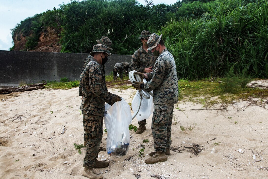 Marines fill bags with trash.