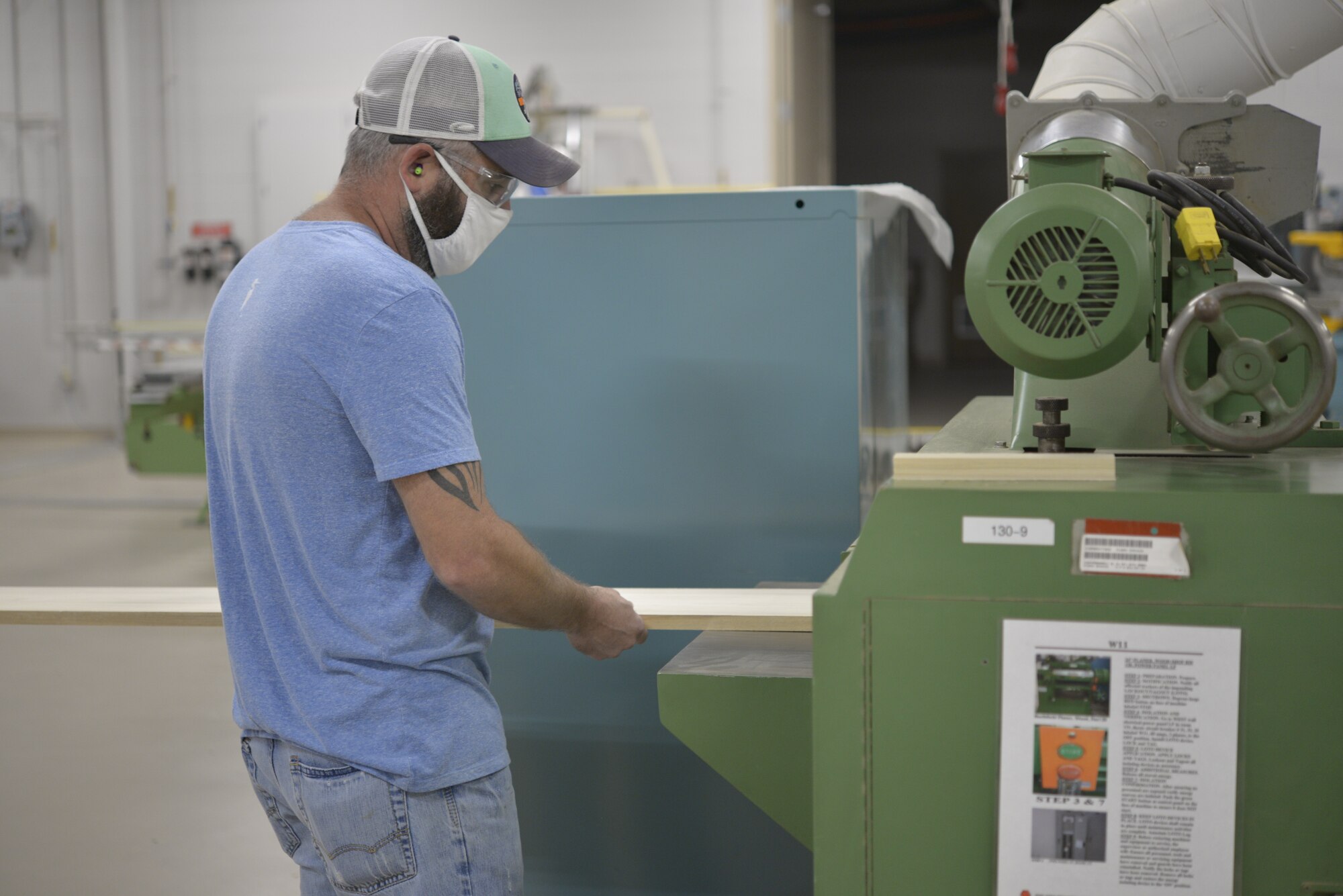 Steven Twinn, 81st Training Support Squadron electronics technician, alters a wooden board for a project in the Trainer Development Center at Keesler Air Force Base, Mississippi, Aug. 12, 2020. The development center crafted 1,500 face shields over six days using a template provided by the Jackson County School District's FabLab, composed of high schoolers from the district. (U.S. Air Force photo by Airman 1st Class Kimberly L. Mueller)