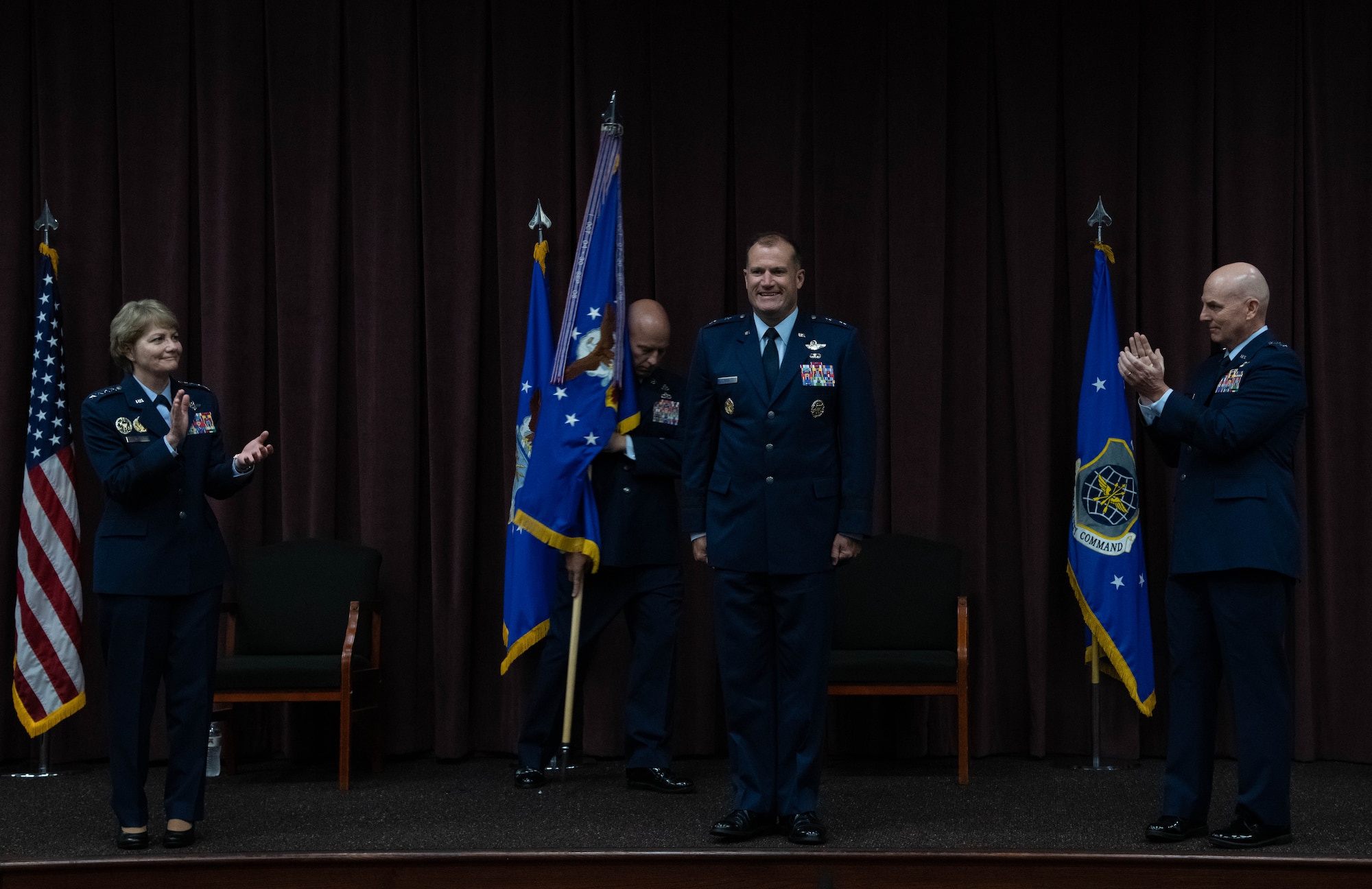 Maj. Gen. Bibb stands between Gen. Miller on the left and Maj. Gen Barrett on the right with Chief Simpson in the back holding the guidon