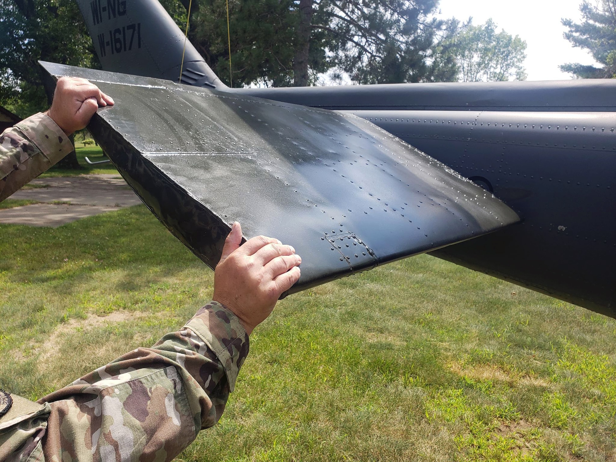 An Air National Guard crew chief assigned to 132nd Wing, Des Moines, Iowa, holds tail of Huey 66-16171