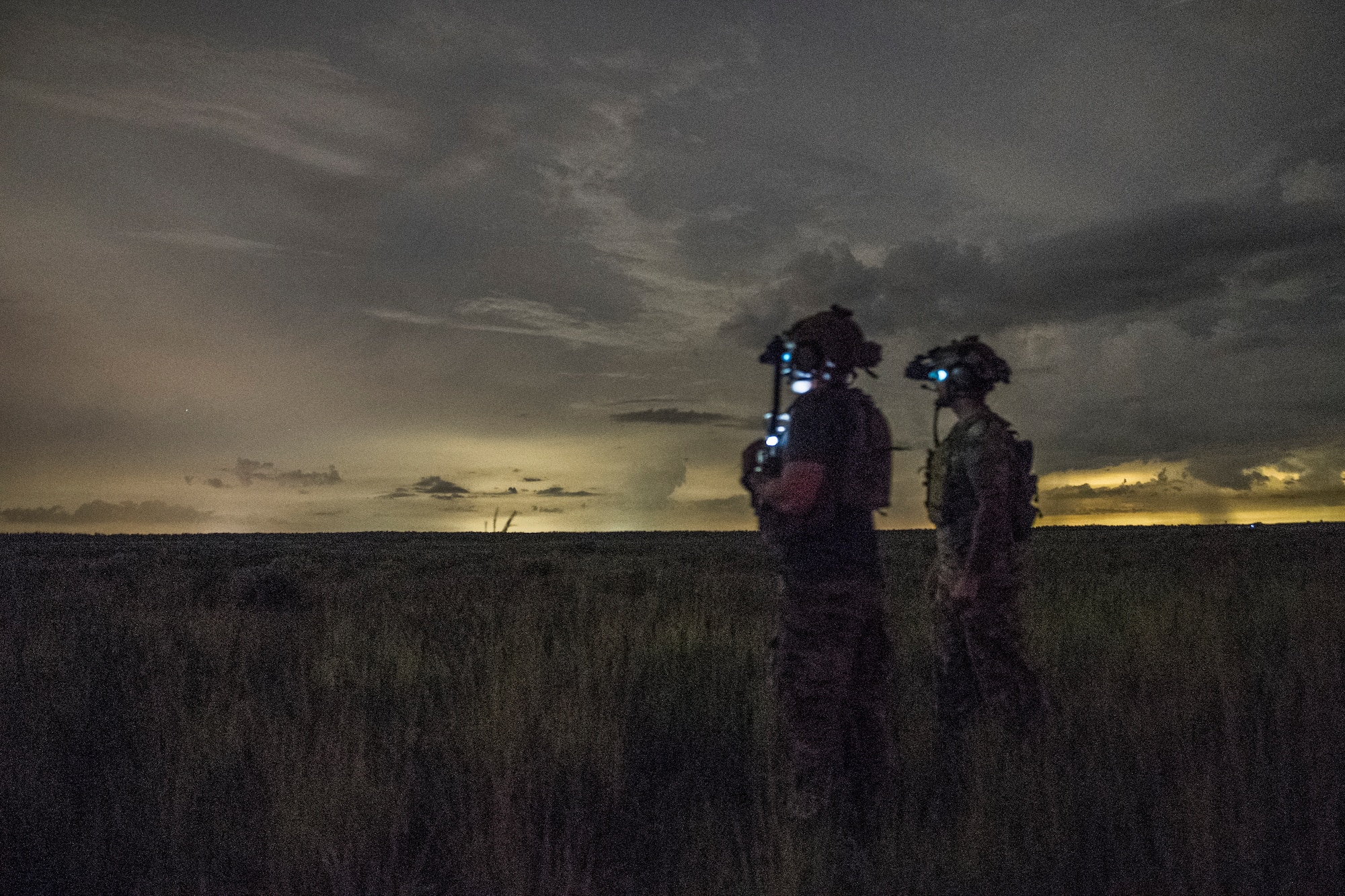 A pair of special operations troops stand facing away from the camera back-lit by a golden sunset. The Army, Air Force, and Marine Corps conducted close air support training during the Special Operations Terminal Attack Controller Course at Avon Park Florida, Aug. 6, 2020