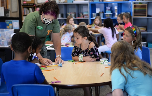 Children watch Lori Amos, Child & Youth Program assistant, work on a duct tape flower project at the Youth Center Aug. 4, 2020, on Columbus AFB, Miss. Along with an active process of new projects and activities, the staff continue to maintain safety with increased sanitation and personal hygiene habits. (U.S. Air Force photo by Airman 1st Class Hannah Bean)