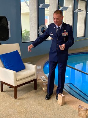 U.S. Air Force Col. David S. Miller, 377th Air Base Wing commander, sprinkles sand from Iwo Jima, Japan at a Hispano Chamber of Commerce event in Albuquerque, New Mexico, August 15, 2020.