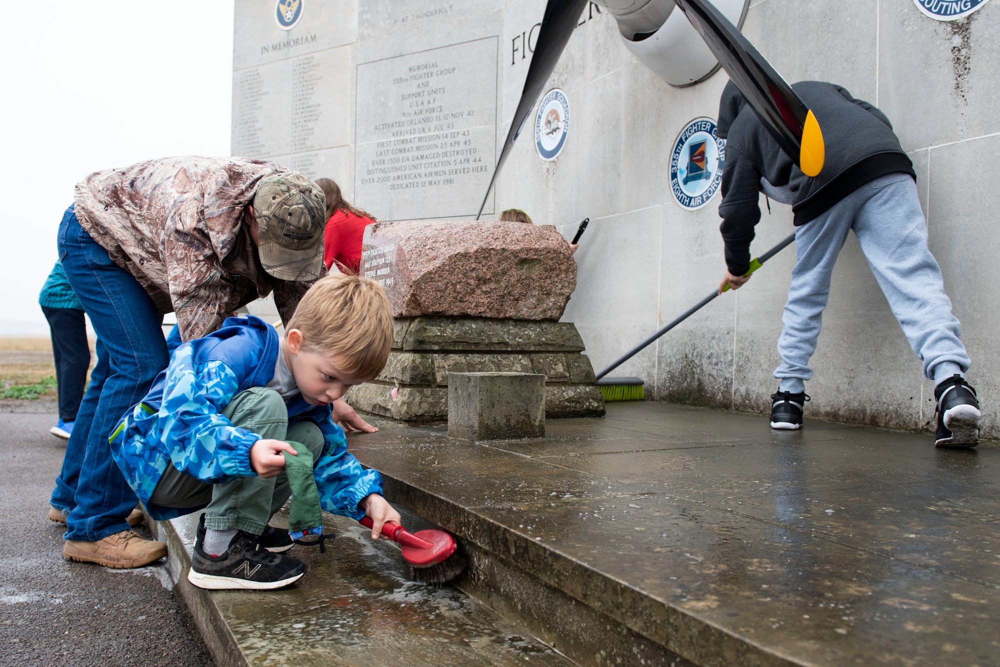 Joshua Dunmire scrubs the 355th Fighter Group Steeple Morden Memorial in Steeple Morden, England, during Operation TORCH-2020 memorial cleanup August 15, 2020. U.S. Africa Command Directorate for Intelligence at RAF Molesworth partnered with the American Battle Monuments Commission to host Operation TORCH-2020, where over 50 military members and their families, U.K. nationals and Boy Scout Troop #245, cleaned six WWII memorial sites to preserve American service member legacies and promote an appreciation of past American heroes among present-day USAFRICOM workforce and families. (U.S. Air Force Photo by Airman 1st Class Jennifer Zima)