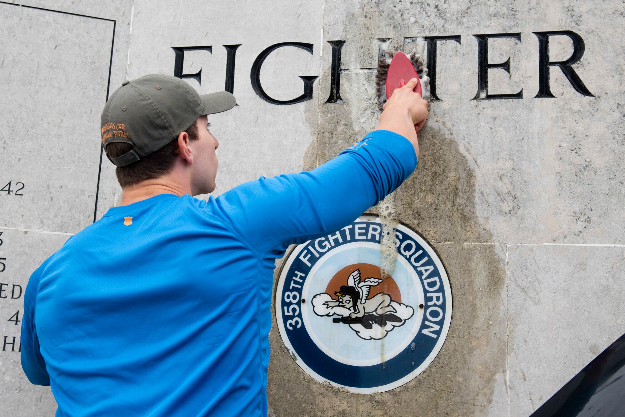 U.S. Navy Petty Officer 2nd Class Sebastian Botero, U.S. Africa Command Directorate for Intelligence at RAF Molesworth technician, scrubs the 355th Fighter Group Steeple Morden Memorial in Steeple Morden, England, during Operation TORCH-2020 memorial cleanup August 15, 2020. U.S. Africa Command Directorate for Intelligence at RAF Molesworth partnered with the American Battle Monuments Commission to host Operation TORCH-2020, where over 50 military members and their families, U.K. nationals and Boy Scout Troop #245, cleaned six WWII memorial sites to preserve American service member legacies and promote an appreciation of past American heroes among present-day USAFRICOM workforce and families. (U.S. Air Force Photo by Airman 1st Class Jennifer Zima)