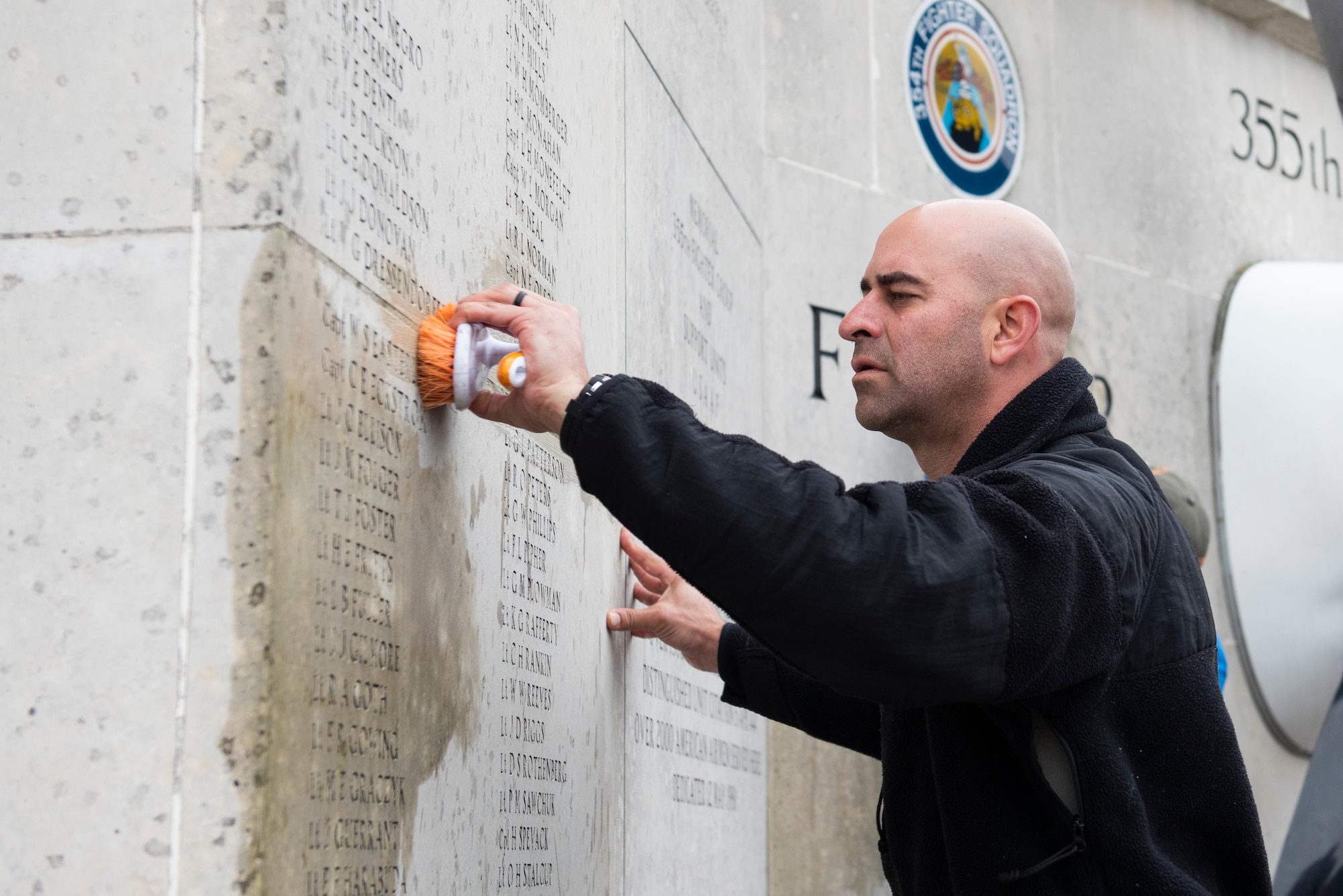 U.S. Air Force Tech. Sgt. Manuel III Minjarez, U.S. Africa Command Directorate for Intelligence at RAF Molesworth technician, scrubs the 355th Fighter Group Steeple Morden Memorial in Steeple Morden, England, during Operation TORCH-2020 memorial cleanup August 15, 2020. U.S. Africa Command Directorate for Intelligence at RAF Molesworth partnered with the American Battle Monuments Commission to host Operation TORCH-2020, where over 50 military members and their families, U.K. nationals and Boy Scout Troop #245, cleaned six WWII memorial sites to preserve American service member legacies and promote an appreciation of past American heroes among present-day USAFRICOM workforce and families. (U.S. Air Force Photo by Airman 1st Class Jennifer Zima)