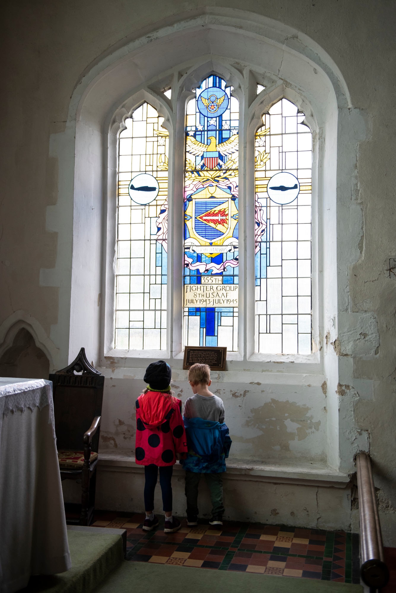 Kaitlyn and Joshua Dunmire look at the memorial window at St. Catherine’s Church in Litlington, England, August 15, 2020. U.S. Africa Command Directorate for Intelligence at RAF Molesworth partnered with the American Battle Monuments Commission to host Operation TORCH-2020, where over 50 military members and their families, U.K. nationals and Boy Scout Troop #245, cleaned six WWII memorial sites to preserve American service member legacies and promote an appreciation of past American heroes among present-day USAFRICOM workforce and families. (U.S. Air Force Photo by Airman 1st Class Jennifer Zima)