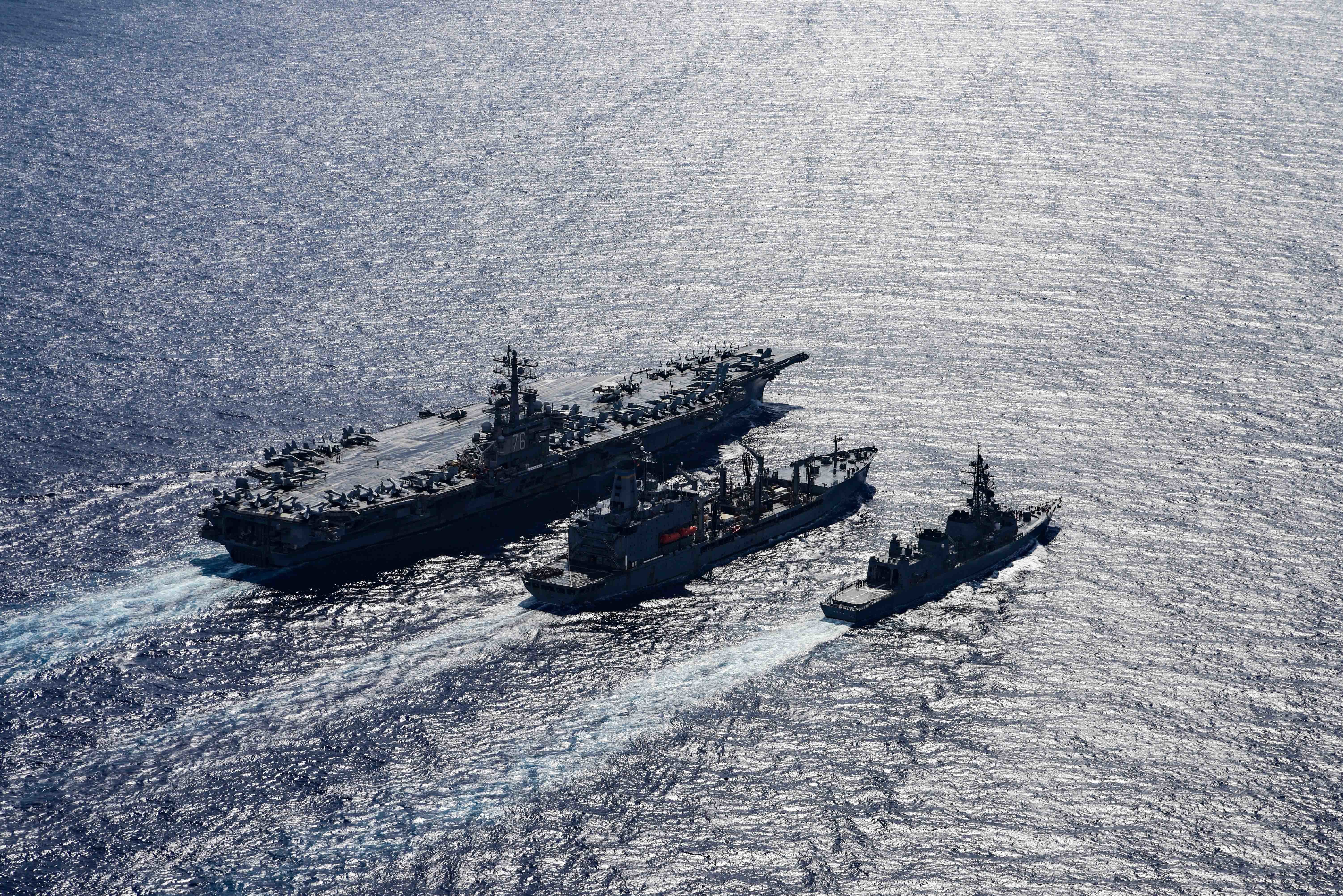 The Navy's only forward-deployed aircraft carrier USS Ronald Reagan (CVN 76), left, fleet replenishment oiler USNS John Ericsson (T-AO 194), middle, and the Japanese Maritime Self-Defense Force Murasame-class destroyer Ikazuchi (JS 107) steam ahead while conducting a replenishment-at-sea.