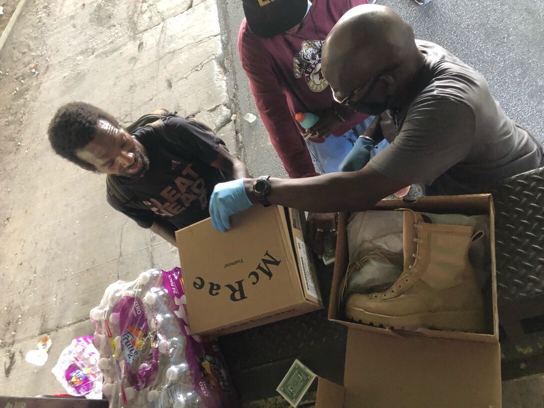 A volunteer for Hosea On the Moves hands out excess military boots received from DLA Disposition Services at Warner Robins, Georgia, during an Aug. 18 homeless outreach on Atlanta.