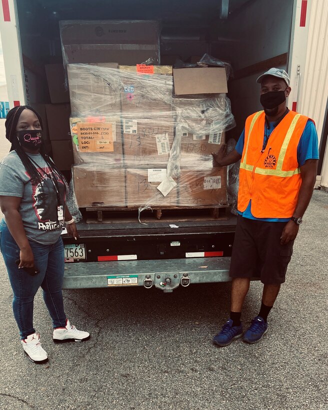 Disposal Service Representative LaVette Rush (left) and customer Hosea Williams (right) as he accepts 189 pairs of boots at DLA Disposition Services at Warner Robins July 28 that will be used to help the homeless.