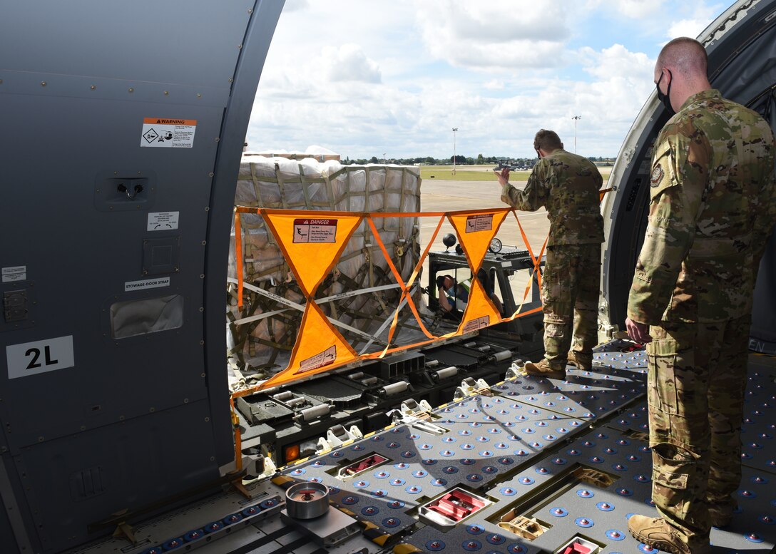 Crew chiefs from the 344th Air Refueling Squadron, McConnell Air Force Base, Kansas, prepare to receive cargo from members of the 727th Air Mobility Squadron on a KC-46A Pegasus at RAF Mildenhall, England, Aug. 18, 2020. The KC-46 has undergone extensive testing this past year, and the successful completion of its first aeromedical evacuation in July 2020 represents a significant milestone in the aircraft’s ability to demonstrate one of its three mission sets: aerial refueling, airlift and aeromedical evacuation.  (U.S. Air Force photo by Karen Abeyasekere)