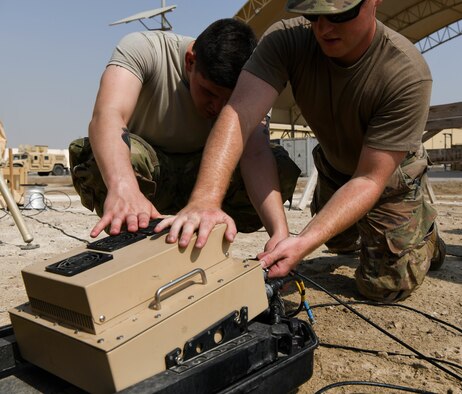 Airman Chandler Harward and Senior Airman Tyler Brown, both members of the 380th Expeditionary Communications Squadron, make connections to the portable Hawkeye satellite communications system Aug. 19, 2020 at Al Dhafra Air Base, United Arab Emirates.