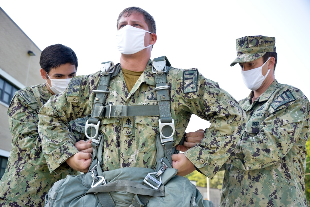 JOINT BASE MCGUIRE-DIX-LAKEHURST, N.J. – Chief Nicholas Clark, a leading chief petty officer with U.S. Navy Explosive Ordnance Disposal Mobile Unit 12 (EODMU-12), tightens the harness on an MC-6 parachute system during an airborne fresher course here on Aug. 12, 2020. Members of the EODMU-12 interacted with U.S. Army Reserve Jumpmasters and paratroopers during training in order to maintain proficiency in conducting joint missions.