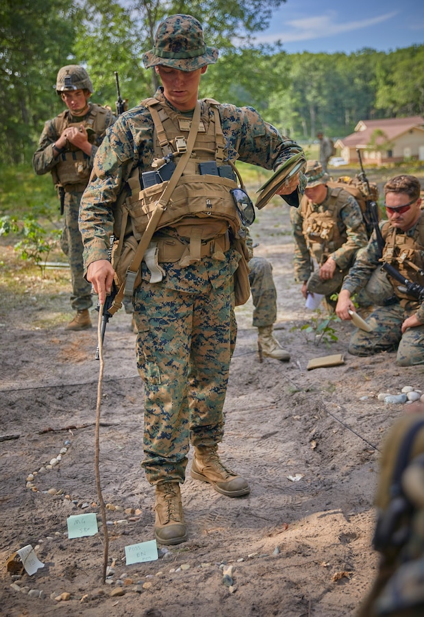 Sgt. Parker Wilkinson, a squad leader with Bravo Company, 1st Battalion, 24th Marine Regiment, 4th Marine Division, provides the course of action to his team members through a model of their upcoming range during their annual training exercise on Camp Grayling, Mich., Aug. 17, 2020. The training and readiness manual gives guidance on the equipment, ammunition, ranges and support requirements to plan and execute effective training to increase Marines’ lethality. (U.S. Marine Corps photo by Lance Cpl. Leslie Alcaraz)