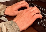 A Washington National Guard member types on a computer. Cybersecurity professionals from the Washington National Guard are assisting the secretary of state’s office to ensure that when a vote is cast in the state, it is counted correctly and accurately.