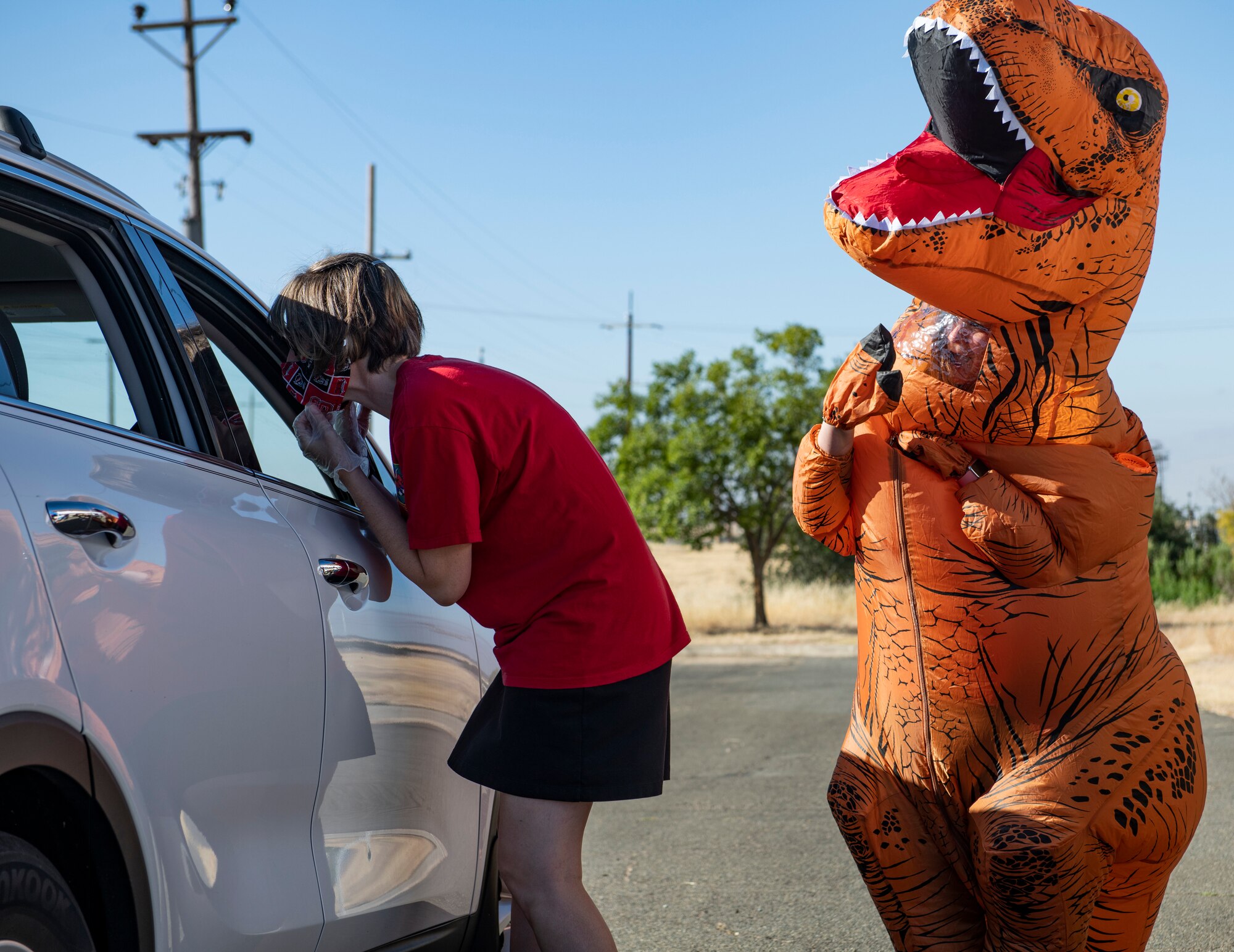 Blair Downs, 9th Force Support Squadron (FSS) marketing director, left, talks to the driver of a car while Kim Hogue, 9th FSS family support coordinator, waves to the children in the back of the car on Beale Air Force Base