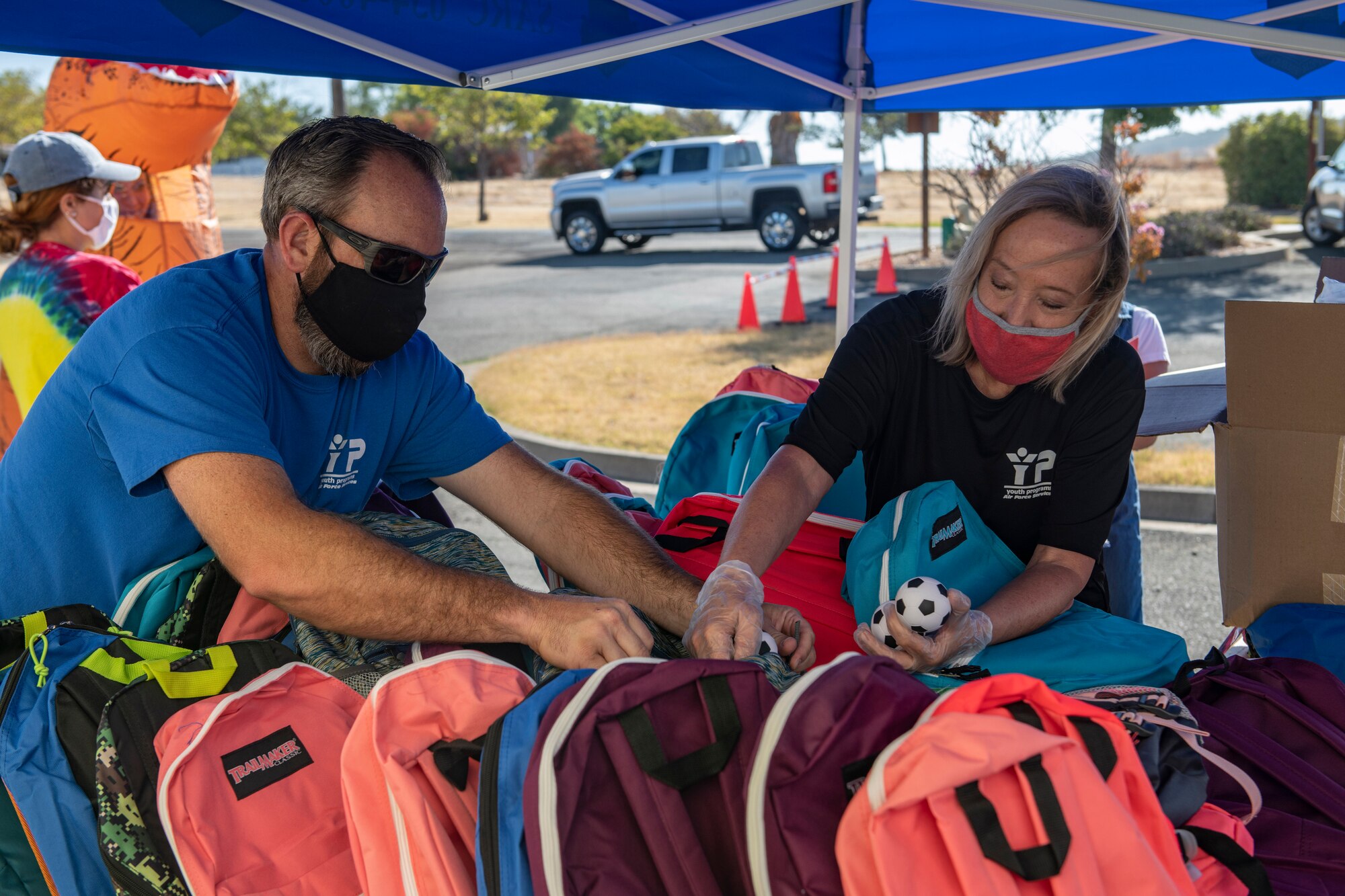 Nick Gasper, 9th Force Support Squadron (FSS) youth sports director, left, and Jeanene Graves, 9th FSS youth program coordinator, pack backpacks on Beale Air Force Base.