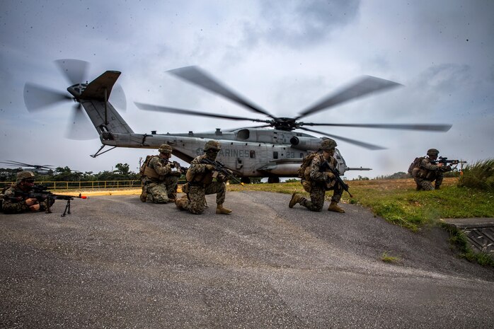 U.S. Marines post security around a CH-53E Super Stallion at the Jungle Warfare Training Center, Okinawa, Japan, Aug. 6.
