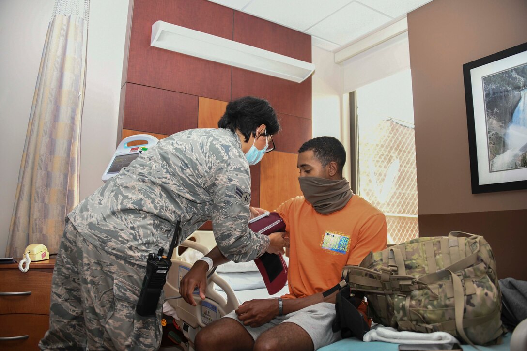 Airman 1st Class Viviana Rolon Acosta, 316th Aeromedical Staging Facility medical technician, checks the vital signs of Spc. Geraldo Arrue, B Battery, 43rd Air Defense Artillery patriot fire control enhanced operator, at Joint Base Andrews, Md., Aug. 13, 2020. Upon arrival of patients to the facility, their vitals are taken and they are given a brief tour of the building. (U.S. Air Force photo by Airman 1st Class Spencer Slocum)