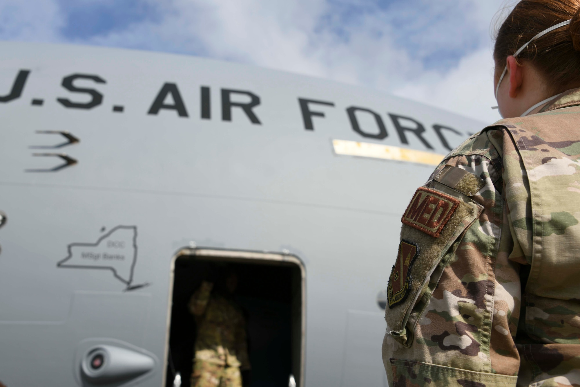 Staff Sgt. Victoria Hansen, 316th Medical Squadron shift leader, awaits the all-clear to come on board a C-17 Globemaster III at Joint Base Andrews, Md., Aug. 13, 2020. Once on board, Hansen and fellow Airmen prepared patients to be offloaded from the aircraft and taken to nearby medical facilities. At a minimum, at least one arrival and two departure missions take place weekly. (U.S. Air Force photo by Airman 1st Class Spencer Slocum)