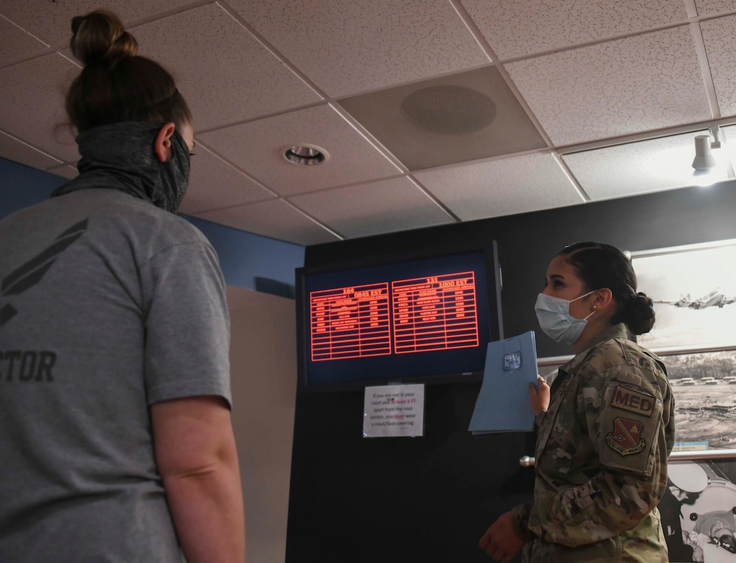 Airman 1st Class Gabriela Preciado, 11th Surgical Operations Squadron medical technician, reviews flight times with a patient at Joint Base Andrews, Md., Aug. 13, 2020. Most patients only stay one night in the Aeromedical Staging Facility before leaving the next day on a different aircraft to their final location. (U.S. Air Force photo by Airman 1st Class Spencer Slocum)