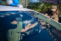 Chief Master Sgt. Michelle Browning hands meals to an Airmen through the driver's side window of their car during a morale event at Creech Air Force Base.