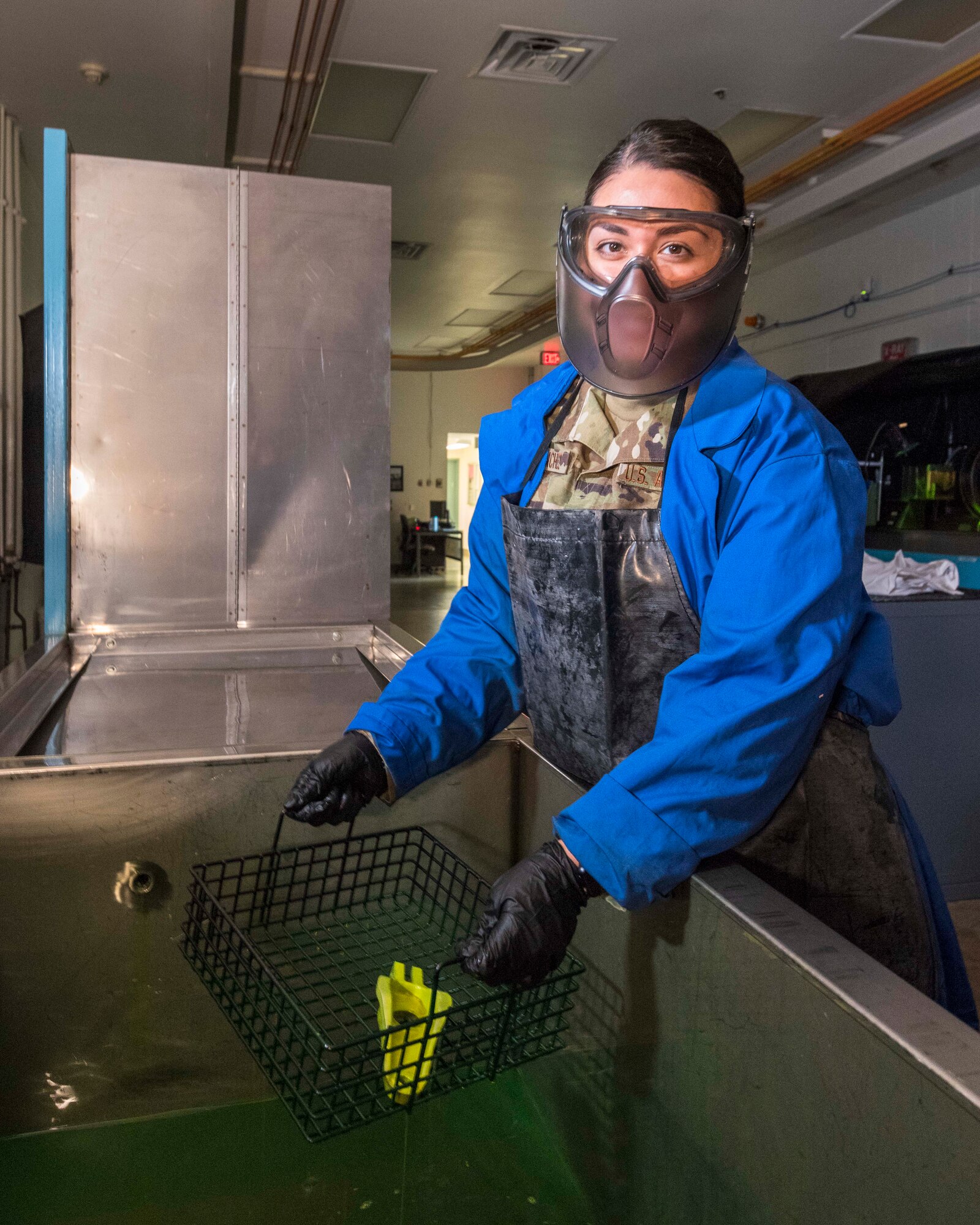Air Force Reserve Staff Sgt. Valerie Sanchez, Air Reserve Technician and non-destructive inspection technician, lifts a tray containing an aircraft part out of a vat of dye at Little Rock Air Force Base, Ark., on Aug. 6, 2020. NDI technicians use various methods to complete these inspections such as X-ray, florescent dye penetrate, oil analysis and ultrasonic scanning to examine and inspect numerous aircraft parts and components to ensure that they are in usable condition. (U.S. Air Force Reserve photo by Maj. Ashley Walker)