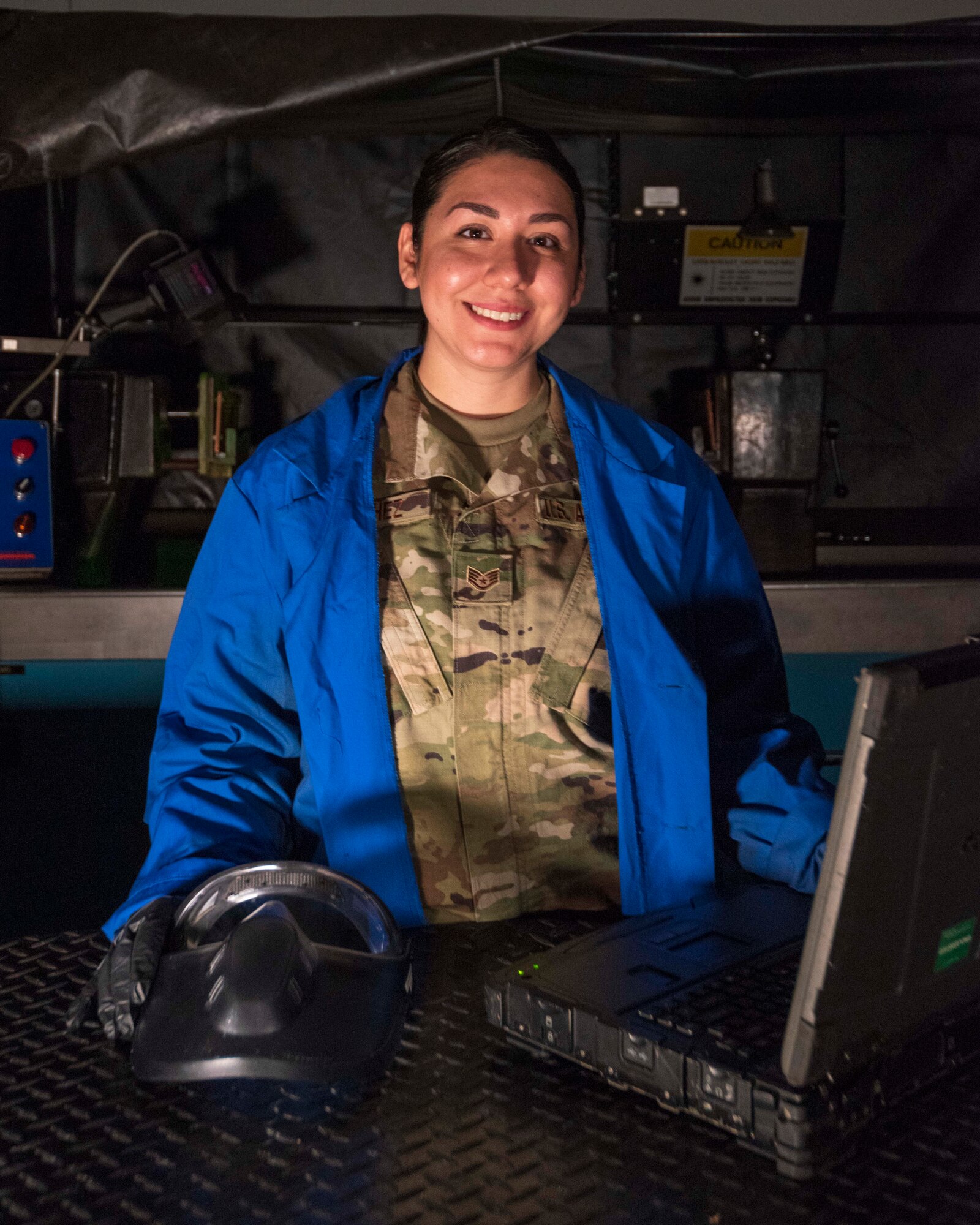 Air Force Reserve Staff Sgt. Valerie Sanchez, Air Reserve Technician and non-destructive inspection technician, poses in front of a maintenance inspection machine at Little Rock Air Force Base, Ark., on Aug. 6, 2020. NDI technicians use various methods to complete these inspections such as X-ray, florescent dye penetrate, oil analysis and ultrasonic scanning to examine and inspect numerous aircraft parts and components to ensure that they are in usable condition. (U.S. Air Force Reserve photo by Maj. Ashley Walker)