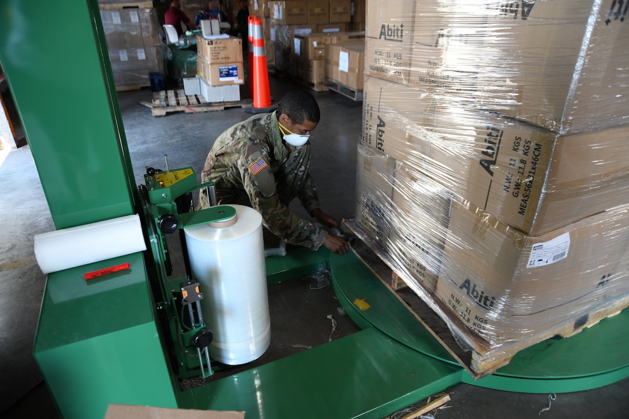 Soldier wraps boxes.