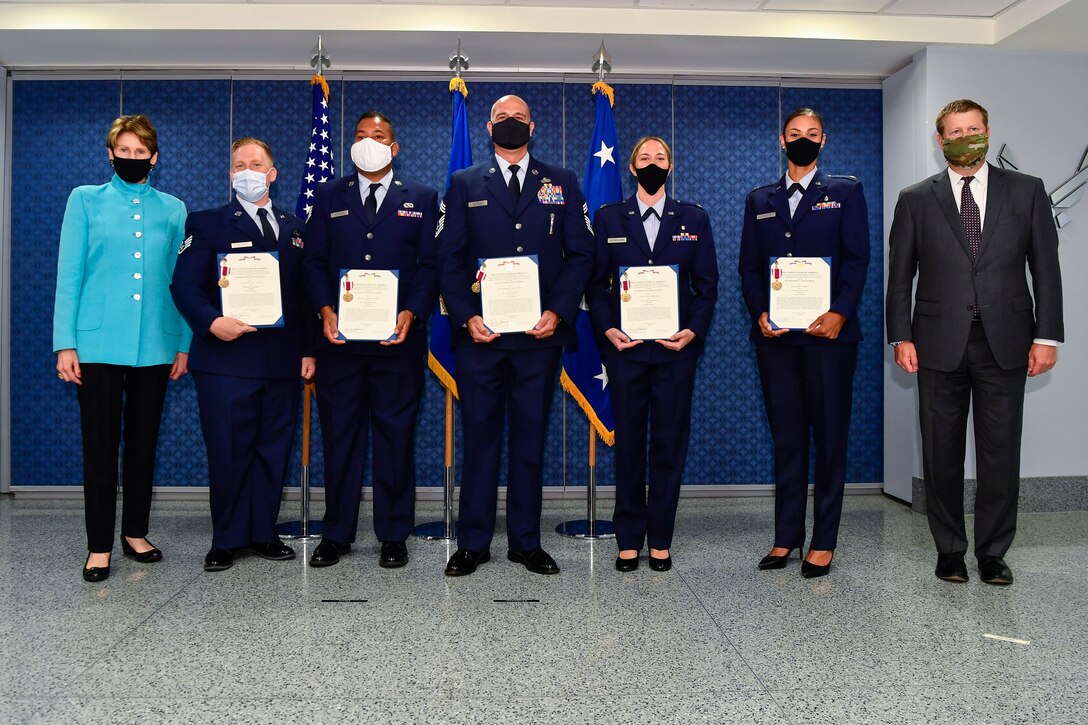 Secretary of the Air Force Barbara M. Barrett and Secretary of the Army Ryan D. McCarthy pose with Air National Guard Airmen who received the Meritorious Service Medal during a ceremony at the Pentagon, Arlington, Va., Aug. 19, 2020. Staff Sgt. Jacen Vaughan, Staff Sgt. Emanuel Morales, Chief Master Sgt. Mark Nicholas, Capt. Lauren Sutherland, Maj. Telisha Johnson and Airman 1st Class Santiago Martinez, who attended via video conference, provided emergency first aid to an unconscious jogger during Civilian Disturbance Response in Washington, D.C., June 4.  (U.S. Air Force photo by Eric Dietrich)