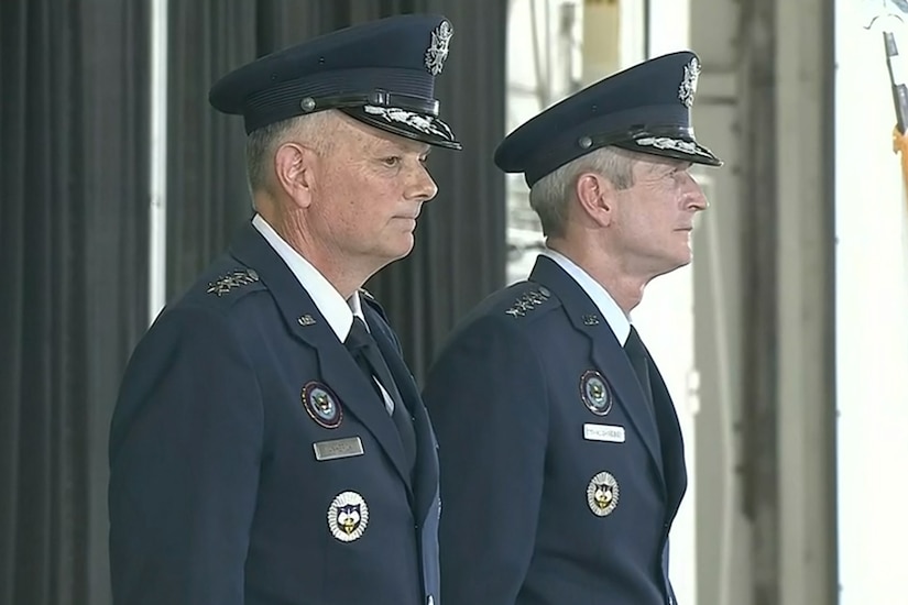 Two men in military uniform stand at attention.