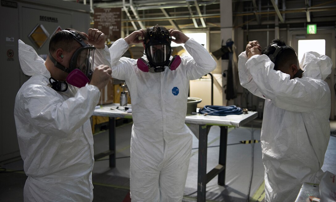 Tech Sgt. Derek Spencer (left), Aircraft Structural Maintenance Craftsman 374th Maintenance Squadron Fabrication Shop, Staff Sgt. Alex Poteet (middle), Aircraft Structural Maintenance Craftsman 374th Maintenance Squadron Fabrication Shop, and Airman 1st Class Isaiahlee Elizardo (right), Aircraft Structural Maintenance Journeyman 374th Maintenance Squadron Fabrication Shop, finish putting on Personal Protective Equipment before applying paint primer to a CV-22 blade at Yokota Air Base Japan, August 12, 2020.