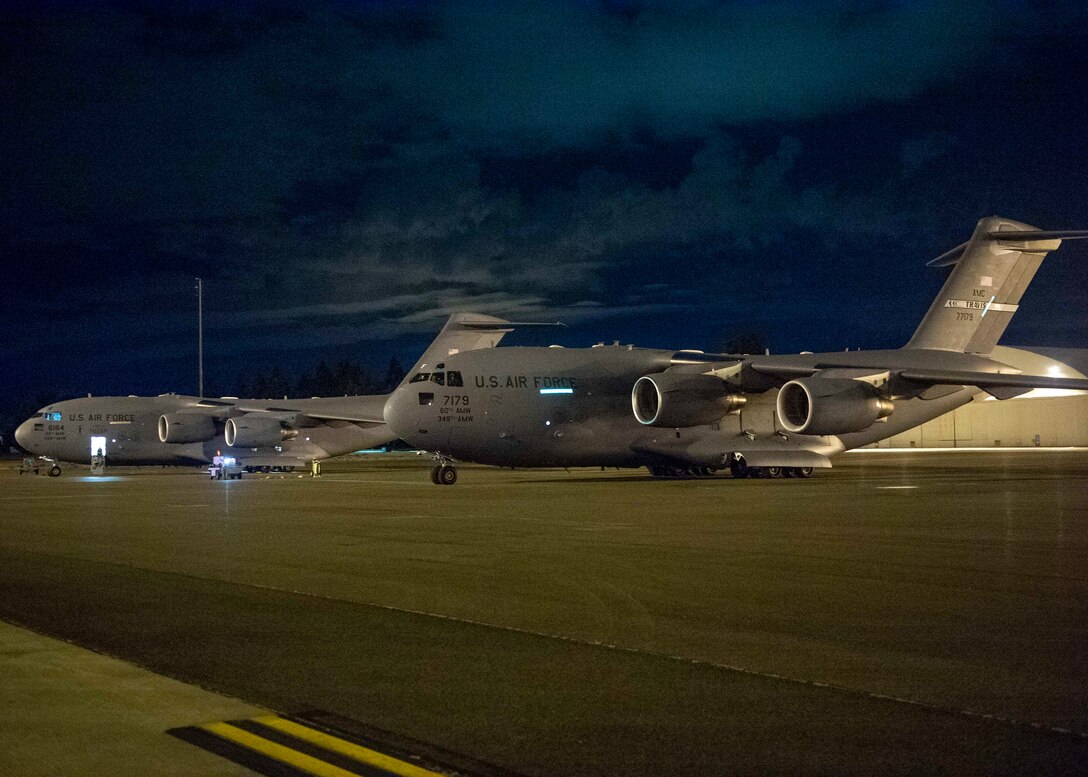 Two C-17 Globemaster III aircraft from Travis Air Force Base, Calif., sit on the flightline at Joint Base Lewis-McChord, Wash., Aug. 20, 2020. Airmen from Team McChord coordinated arrival and transportation for air crews of four Travis AFB C-17s after they evacuated due to fires near Fairfield and Vacaville, Calif. (U.S. Air Force photo by Senior Airman Sara Hoerichs)