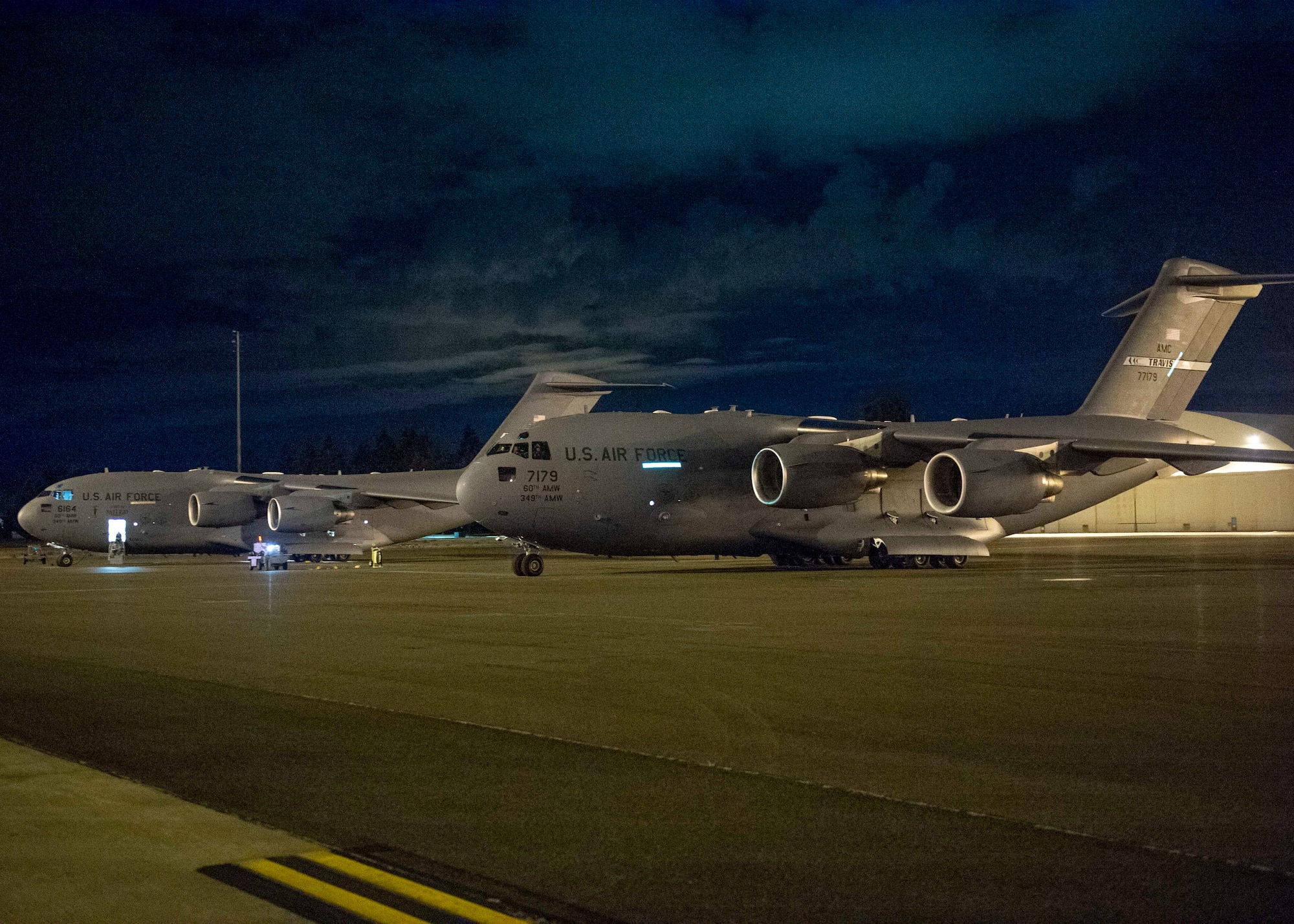 Two C-17 Globemaster III aircraft from Travis Air Force Base, Calif., sit on the flightline at Joint Base Lewis-McChord, Wash., Aug. 20, 2020. Airmen from Team McChord coordinated arrival and transportation for air crews of four Travis AFB C-17s after they evacuated due to fires near Fairfield and Vacaville, Calif. (U.S. Air Force photo by Senior Airman Sara Hoerichs)