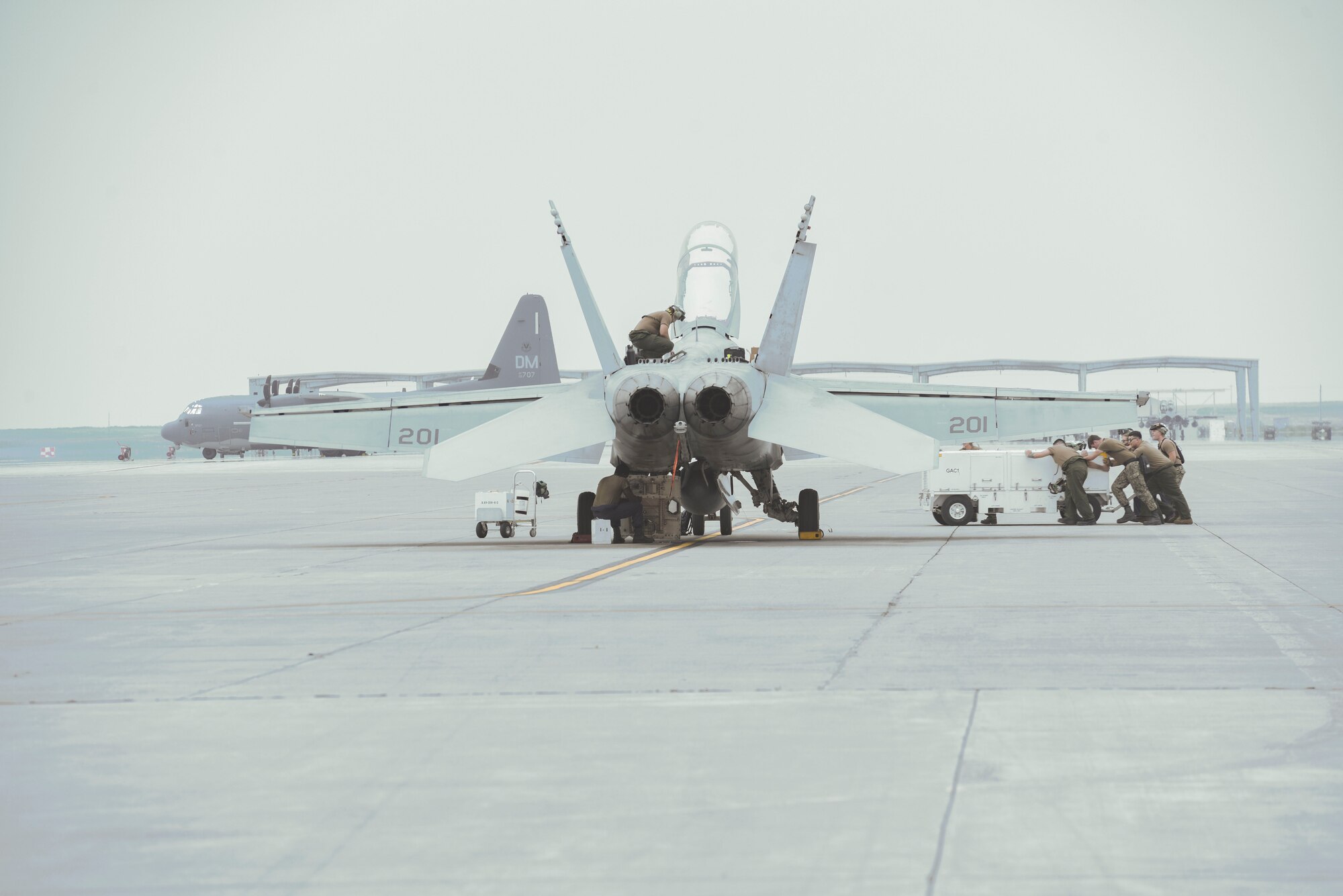 U.S. Navy Seamen perform maintenance on a F/A-18 Hornet from the 213th Strike Fighter Squadron during Gunfighter Flag 20-1, August 19, 2020, at Mountain Home Air Force Base, Idaho. GFF 20-1 provides units the opportunity to train with joint and international partners to complete combat and rescue exercises. (U.S. Air Force photo by Airman 1st Class Akeem Campbell)