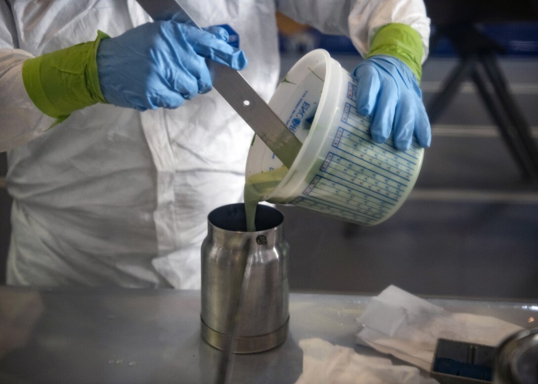 Staff Sgt. Alex Poteet, Aircraft Structural Maintenance Craftsman 374th Maintenance Squadron Fabrication Shop, mixes paint primer before applying to the CV-22 blade at Yokota Air Base, Japan, August 12, 2020. Paint primer is applied before applying rain erosion protectant and the final top coat of paint on the CV-22 blade. (U.S. Air Force photo by Staff Sgt. Ryann Holzapfel)