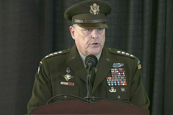 A man in a U.S. Army uniform stands at a microphone on a lectern.
