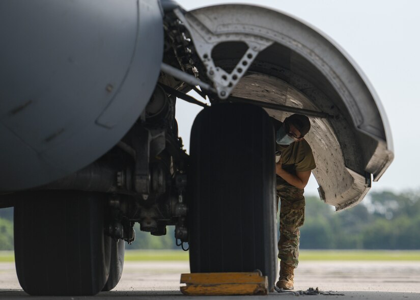 Airman 1st Class Brian Ireta, an aerospace mechanic assigned to the 437th Aircraft Maintenance Squadron, checks the tire pressure on a C-17 Globemaster III at Joint Base Charleston, S.C., Aug. 18, 2020. The 437th AMXS inspects, services, and maintains the assigned C-17 aircraft at Joint Base Charleston.