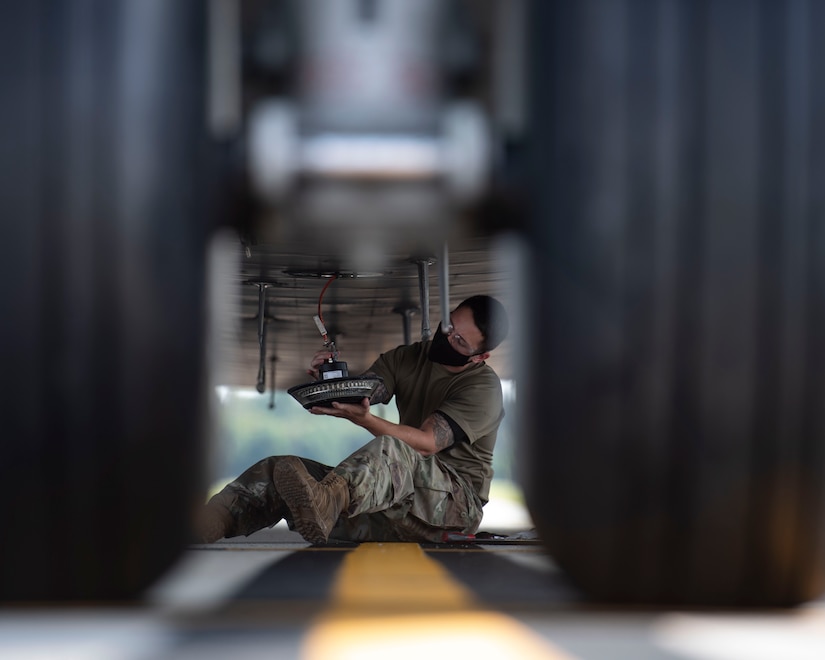 Staff Sgt. Brandon Whitley, an aerospace mechanic assigned to the 437th Aircraft Maintenance Squadron, connects an anti-collision light to the bottom of a C-17 Globemaster III at Joint Base Charleston, S.C., Aug. 18, 2020. The 437th AMXS inspects, services, and maintains the assigned C-17 aircraft at Joint Base Charleston.