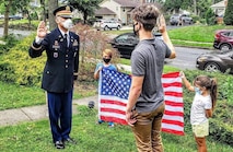 Future Soldier Ronald Kaszian Sauerbrey receives his Oath of Enlistment from company commander Capt. Mehmet Bahadir, while his younger siblings hold the American flag behind them.