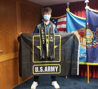 Young white male holds Army flag inside MEPS