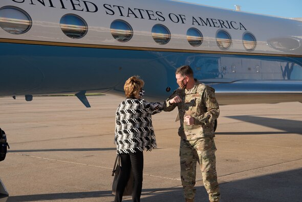 Hon. Lord touching elbows with Lt. Gen. Kirkland in front of aircraft.